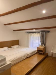a bedroom with a large bed and a window at Gulangyu Sunlit Rock Garden Resort in Xiamen