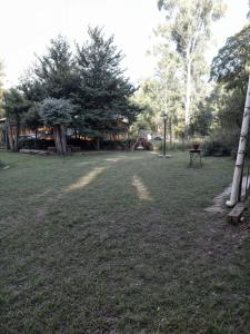 a grass field with a picnic table and trees at La Rustica in El Durazno +1 photo