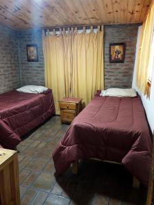 a bedroom with two beds and a wooden ceiling at La Rustica in El Durazno