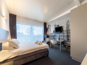 a hotel room with a bed and a desk at Villa near Teuge Airport and Paleis 't Loo in Teuge