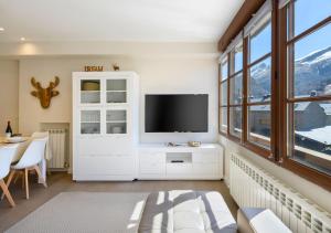 un soggiorno con televisione e tavolo di Cambaz 1 Exclusivo Dúplex Privado a Panticosa
