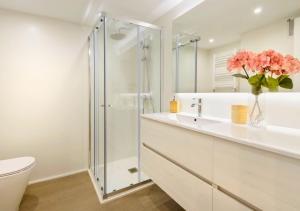 un bagno con doccia e vaso di fiori rosa di Cambaz 1 Exclusivo Dúplex Privado a Panticosa Altre 7 foto