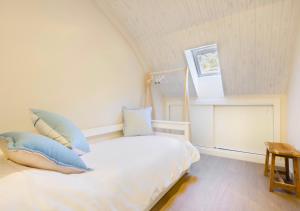 una camera da letto con un letto bianco con cuscini blu di Cambaz 1 Exclusivo Dúplex Privado a Panticosa