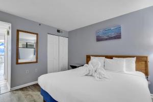 a bedroom with a large white bed and a window at Oceanfront Condo at Meridian Plaza in Myrtle Beach