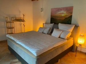 a bedroom with a bed with white sheets and pillows at Ferienhaus am Feld nahe Berlin in Kolonie Fredersdorf +9 photos