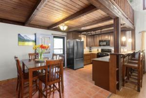 a kitchen with a table and chairs and a refrigerator at Summit Mountain Lodge and Steakhouse in East Glacier Park