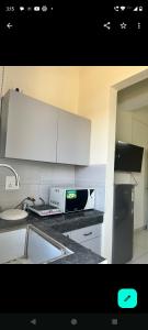 una cocina con fregadero y microondas en Cute apartment, en Zirakpur