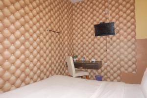 ein Schlafzimmer mit einem Bett und einem Schreibtisch mit Fernseher in der Unterkunft Louise Hotel in Glugur