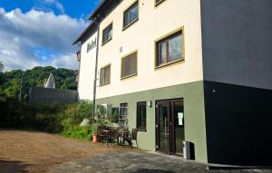 a building with a table and chairs in front of it at Alembra - Hotel zur Moselbrücke in Schweich
