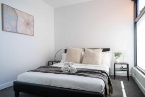 Modern 2B Apt with Views Near Swinburne University في ملبورن: غرفة نوم بها سرير عليه منشفتان