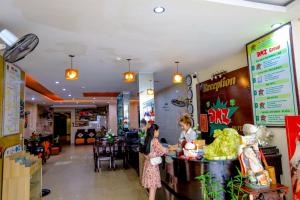 two women standing at the counter of a restaurant at DMZ Hotel ,Central Hue ,Near Perfume River in Hue