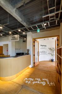 an office with a reception desk and a sign on the wall at Regions Hostel in Yokote +61 photos