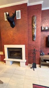 a living room with a fireplace and a mask on the wall at Top of the Mountain Гранд Манастира частни Апартаменти in Pamporovo