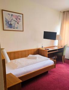a bedroom with a bed and a desk with a computer at Alembra - Hotel zur Moselbrücke in Schweich
