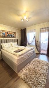 a bedroom with a large bed and a rug at Top of the Mountain Гранд Манастира частни Апартаменти in Pamporovo
