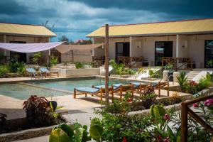 a resort with a swimming pool and a building at Blooming Zanzibar in Jambiani
