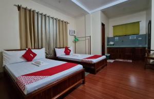 a bedroom with two beds with red pillows at Roccksar Pension House in Puerto Princesa City