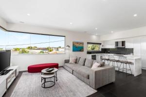 a living room with a couch and a kitchen at Stylish getaway near beach with stunning sunsets in Saint Leonards