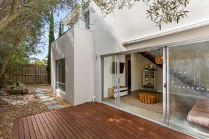 an extension of a house with a deck and sliding glass doors at Stylish getaway near beach with stunning sunsets in Saint Leonards +11 photos