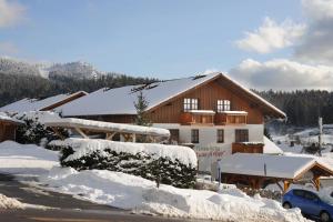 a house covered in snow in front at Ferien- und Aktivhotel Zum Arber in Bodenmais