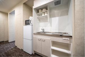a kitchen with a white refrigerator and a sink at RESI STAY Kuon in Kyoto