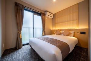 a hotel room with a bed and a large window at RESI STAY Kuon in Kyoto