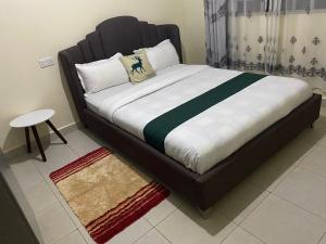 1 cama con cabecero negro en una habitación en Croft Home, en Eldoret
