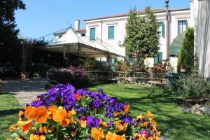 un giardino fiorito di fronte a una casa di Agriturismo Le Clementine a Badia Polesine