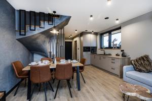 a dining room and kitchen with a table and chairs at Tatra Bliss Apartments- Białka Tatrzańska in Białka Tatrzanska +51 photos