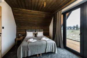 a bedroom with a bed with a wooden ceiling at Tatra Bliss Apartments- Białka Tatrzańska in Białka Tatrzanska