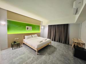 a bedroom with a bed and a green painting on the wall at Chill Chill Hotel in Krabi