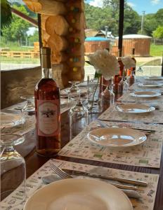 a table with plates and a bottle of wine at Chalet in Muntii Vrancei - Gresu - Lepsa cu Ciubar si Sauna in Greşu