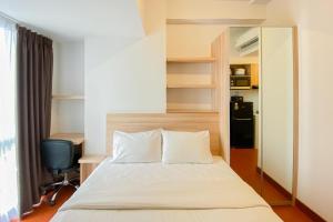 RawalembangModern Look Studio at Tokyo Riverside PIK 2 Apartment By Travelio的一间卧室，配有一张床、一张桌子和一把椅子