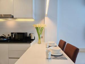a kitchen with a table with cups and bowls on it at Karon Utopia in Karon Beach