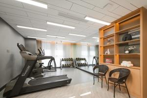 a room with a gym with a treadmill and chairs at Metropolo, Shaoxing, Wanda Plaza-Keqiao in Shaoxing