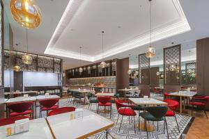 a restaurant with tables and chairs and a projection screen at Metropolo, Shaoxing, Wanda Plaza-Keqiao in Shaoxing