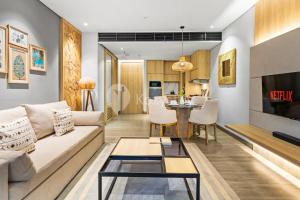 una sala de estar con un sofá y una mesa en Moriya by Kozystay - Nusa Dua, en Nusa Dua