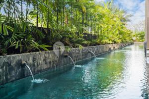 una piscina de agua con dos fuentes de agua en Moriya by Kozystay - Nusa Dua, en Nusa Dua