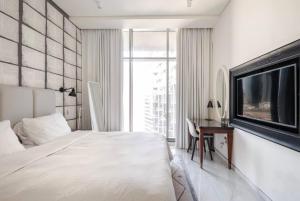 una camera con letto, TV e scrivania di Atria Business Bay a Dubai
