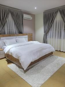 a bedroom with a large bed with white sheets at Terra Verte Court in Accra