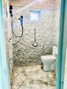 a bathroom with a toilet and a shower at Ashok villa in Weligama