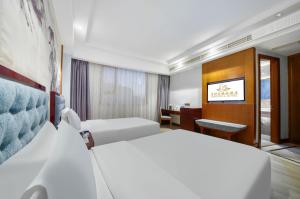 Una habitación de hotel con dos camas y un escritorio. en Hendra Hotel - Wenzhou Longwan International Airport Yongzhong Metro Station Branch, en Wenzhou