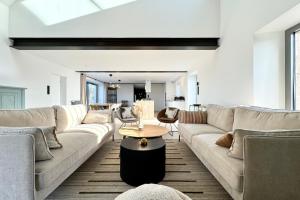 a living room with couches and a table at Exceptionnel ! Longère rénovée Archi Cocooning in Plouhinec