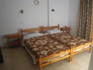 a bedroom with a wooden bed and two pillows at Pension Annoula in Archangelos