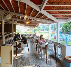 a group of people sitting at tables in a restaurant at Carina Beach Resort in Benaulim +96 photos