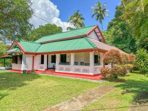 ein Haus mit einem grünen Dach und einem Hof in der Unterkunft Elmwon Heritage in Matara