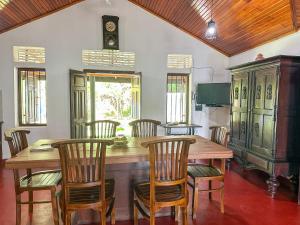 ein Esszimmer mit einem Holztisch und Stühlen in der Unterkunft Elmwon Heritage in Matara