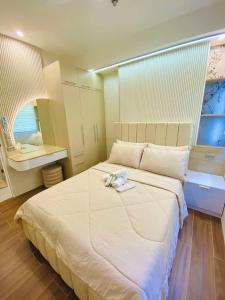 a bedroom with a large white bed with a mirror at Matina Enclave in Davao City