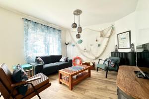 a living room with a couch and a table at Maison de pêcheur Rénovée À 50m des plages in Riantec