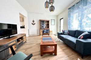 a living room with a couch and a tv at Maison de pêcheur Rénovée À 50m des plages in Riantec